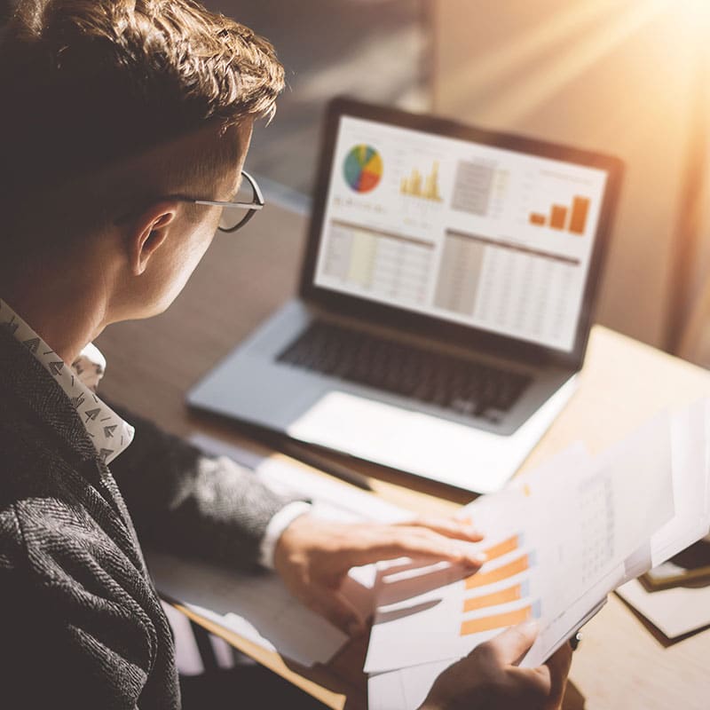 A person analyzing charts and graphs at a desk